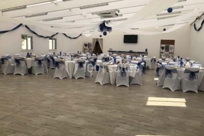 Canapé gris avec coussins, table basse avec magazines et télécommande, tableau mural et fenêtre laissant entrer la lumière.