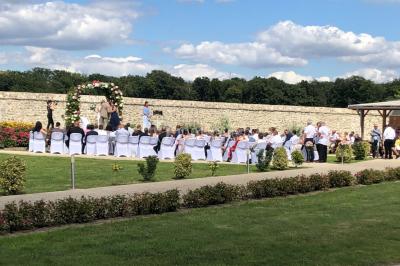 Canapé gris avec coussins, table basse avec magazines et télécommande, tableau mural et fenêtre laissant entrer la lumière.