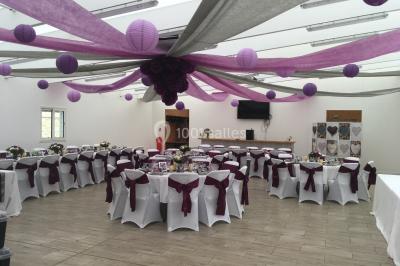 Canapé gris avec coussins, table basse avec magazines et télécommande, tableau mural et fenêtre laissant entrer la lumière.