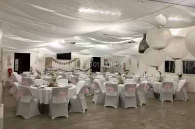 Canapé gris avec coussins, table basse avec magazines et télécommande, tableau mural et fenêtre laissant entrer la lumière.