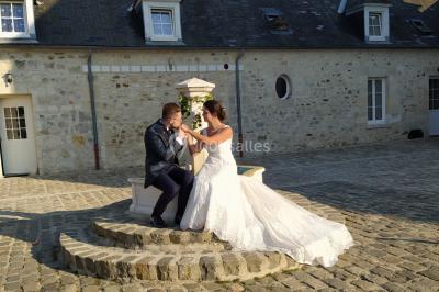 Canapé gris avec coussins, table basse avec magazines et télécommande, tableau mural et fenêtre laissant entrer la lumière.