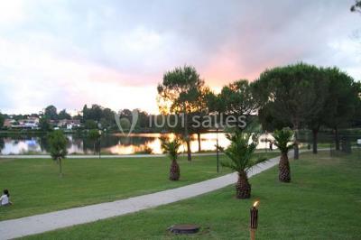 Salle de bowling avec plusieurs pistes, boules colorées au premier plan et décorations murales en bois et surf.