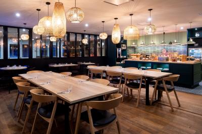 Salle de bowling avec plusieurs pistes, boules colorées au premier plan et décorations murales en bois et surf.