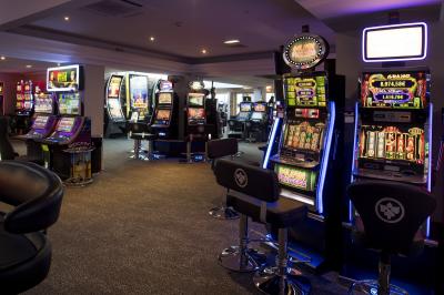 Salle de bowling avec plusieurs pistes, boules colorées au premier plan et décorations murales en bois et surf.