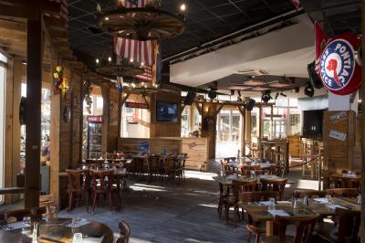 Salle de bowling avec plusieurs pistes, boules colorées au premier plan et décorations murales en bois et surf.