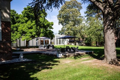 Entrée élégante avec un sol en mosaïque, un lustre en cristal, deux vases décoratifs et une statue en bois.