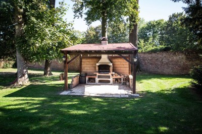 Entrée élégante avec un sol en mosaïque, un lustre en cristal, deux vases décoratifs et une statue en bois.