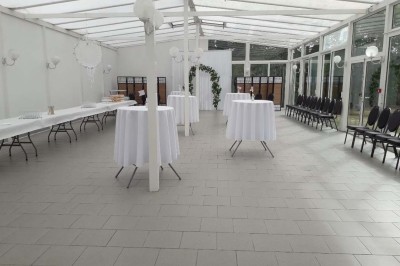 Entrée élégante avec un sol en mosaïque, un lustre en cristal, deux vases décoratifs et une statue en bois.