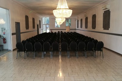 Entrée élégante avec un sol en mosaïque, un lustre en cristal, deux vases décoratifs et une statue en bois.