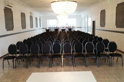 Entrée élégante avec un sol en mosaïque, un lustre en cristal, deux vases décoratifs et une statue en bois.