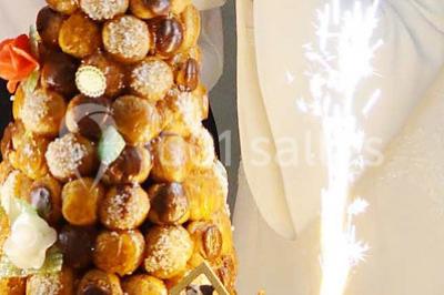 Salle lumineuse avec une grande table dressée pour un repas, décorée de fleurs et entourée de baies vitrées donnant sur un…