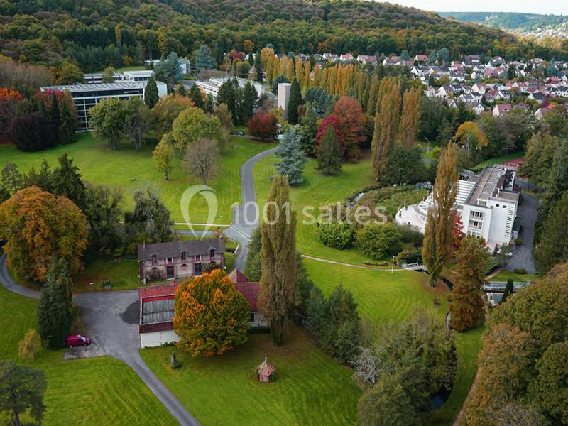 Vue aérienne d'un parc arboré en automne avec des bâtiments résidentiels et institutionnels entourés de verdure.