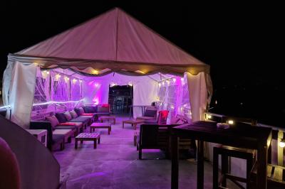 Buffet coloré avec pains, brochettes de fruits, charcuteries et décorations florales en fruits exotiques.