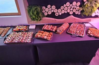 Buffet coloré avec pains, brochettes de fruits, charcuteries et décorations florales en fruits exotiques.