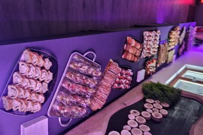 Buffet coloré avec pains, brochettes de fruits, charcuteries et décorations florales en fruits exotiques.