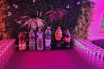 Buffet coloré avec pains, brochettes de fruits, charcuteries et décorations florales en fruits exotiques.