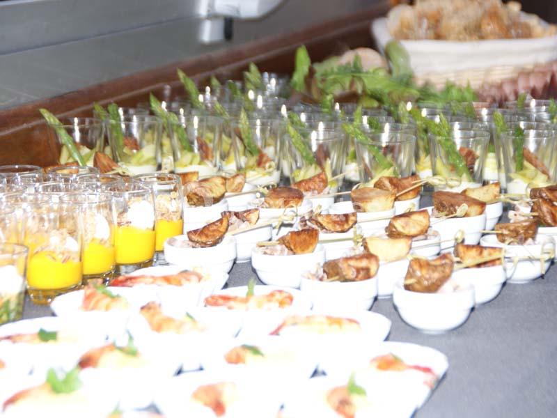 Plateau de verrines et amuse-bouches variés disposés sur une table pour un buffet.