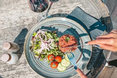 Assiette contenant des feuilles de radicchio garnies de foie gras et de morceaux de pomme disposés en étoile.