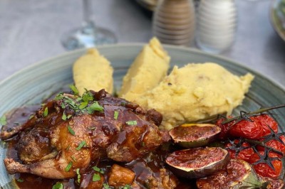 Assiette contenant des feuilles de radicchio garnies de foie gras et de morceaux de pomme disposés en étoile.