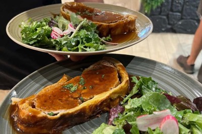 Assiette contenant des feuilles de radicchio garnies de foie gras et de morceaux de pomme disposés en étoile.