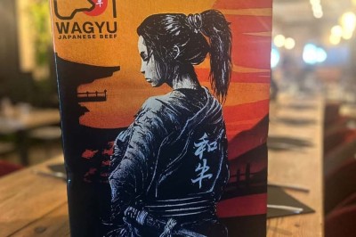 Assiette contenant des feuilles de radicchio garnies de foie gras et de morceaux de pomme disposés en étoile.