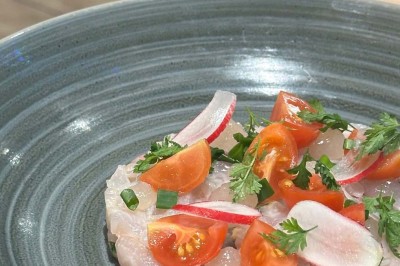 Assiette contenant des feuilles de radicchio garnies de foie gras et de morceaux de pomme disposés en étoile.