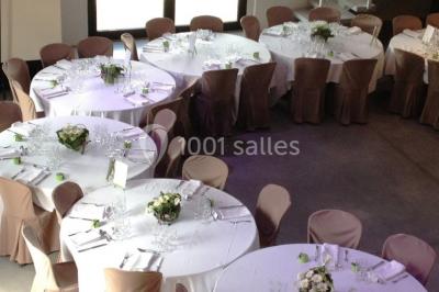 Salle spacieuse avec murs en briques, poutres apparentes, éclairage moderne et comptoirs lumineux rouges.
