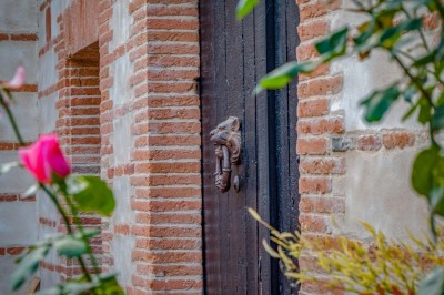 Salle spacieuse avec mezzanine, poutres apparentes, tables et chaises empilées, éclairage chaleureux.