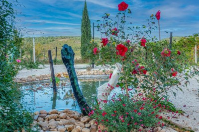 Salle spacieuse avec mezzanine, poutres apparentes, tables et chaises empilées, éclairage chaleureux.