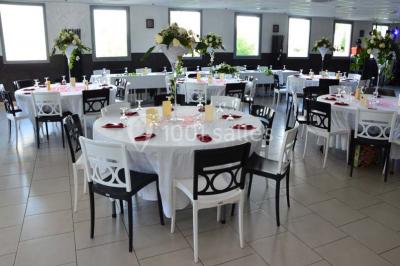 Assiette de saumon fumé avec tranches de citron vert, toasts garnis de crème et tomate, présentée sur un fond noir.