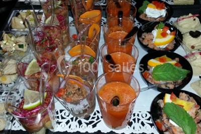 Assiette de saumon fumé avec tranches de citron vert, toasts garnis de crème et tomate, présentée sur un fond noir.