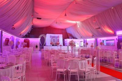 Parking vide avec marquages au sol, entouré de bâtiments industriels et d'arbres sous un ciel dégagé.