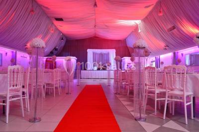 Parking vide avec marquages au sol, entouré de bâtiments industriels et d'arbres sous un ciel dégagé.