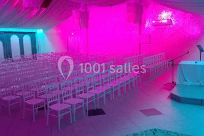 Parking vide avec marquages au sol, entouré de bâtiments industriels et d'arbres sous un ciel dégagé.