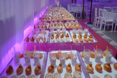 Parking vide avec marquages au sol, entouré de bâtiments industriels et d'arbres sous un ciel dégagé.