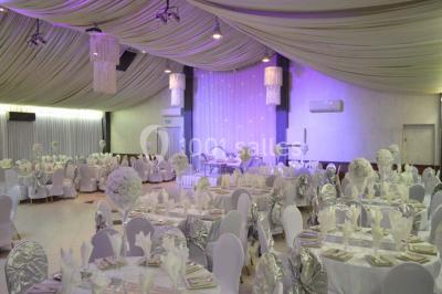 Parking vide avec marquages au sol, entouré de bâtiments industriels et d'arbres sous un ciel dégagé.