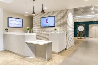 Terrasse avec des tables et chaises bleues, entourée de jardinières et d'une structure métallique végétalisée.