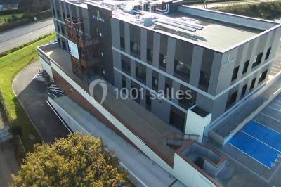 Terrasse avec des tables et chaises bleues, entourée de jardinières et d'une structure métallique végétalisée.