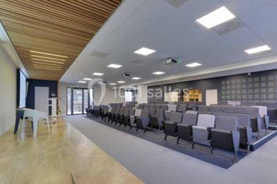 Terrasse avec des tables et chaises bleues, entourée de jardinières et d'une structure métallique végétalisée.