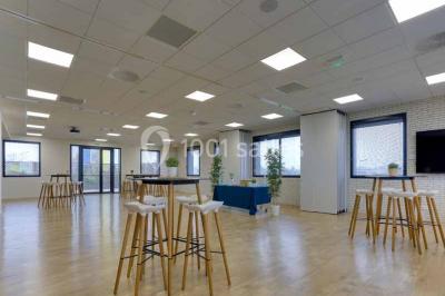Terrasse avec des tables et chaises bleues, entourée de jardinières et d'une structure métallique végétalisée.