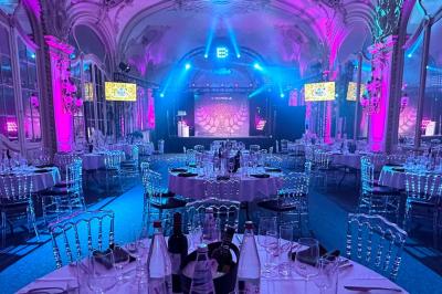 Salle avec des fauteuils rayés colorés, murs recouverts de végétation et éclairage tamisé.