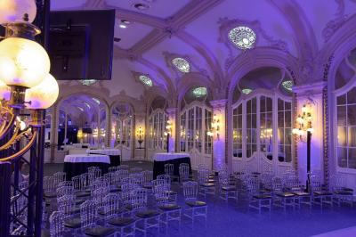 Salle avec des fauteuils rayés colorés, murs recouverts de végétation et éclairage tamisé.