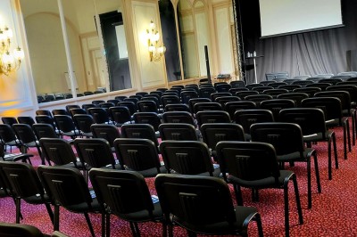 Salle avec des fauteuils rayés colorés, murs recouverts de végétation et éclairage tamisé.