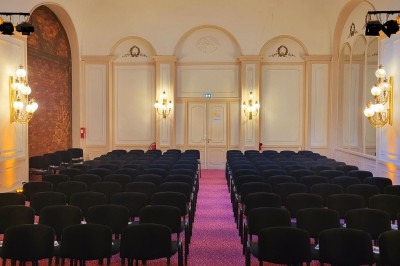 Salle avec des fauteuils rayés colorés, murs recouverts de végétation et éclairage tamisé.