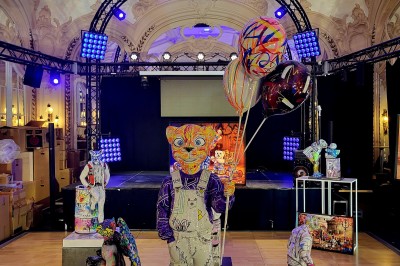 Salle avec des fauteuils rayés colorés, murs recouverts de végétation et éclairage tamisé.