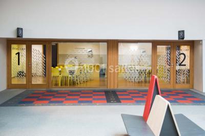 Un groupe de personnes rassemblé sous un grand parasol éclairé par des lumières violettes, dans un jardin de nuit.