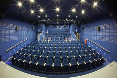 Un groupe de personnes rassemblé sous un grand parasol éclairé par des lumières violettes, dans un jardin de nuit.