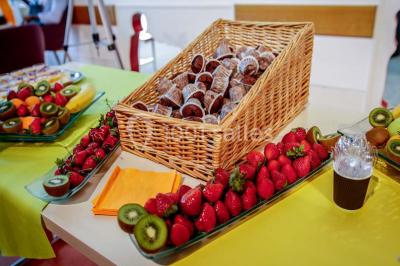 Un groupe de personnes rassemblé sous un grand parasol éclairé par des lumières violettes, dans un jardin de nuit.