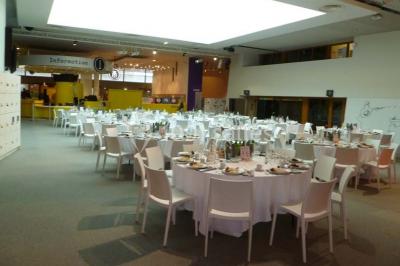 Un groupe de personnes rassemblé sous un grand parasol éclairé par des lumières violettes, dans un jardin de nuit.