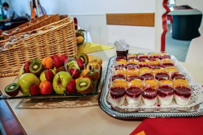 Un groupe de personnes rassemblé sous un grand parasol éclairé par des lumières violettes, dans un jardin de nuit.